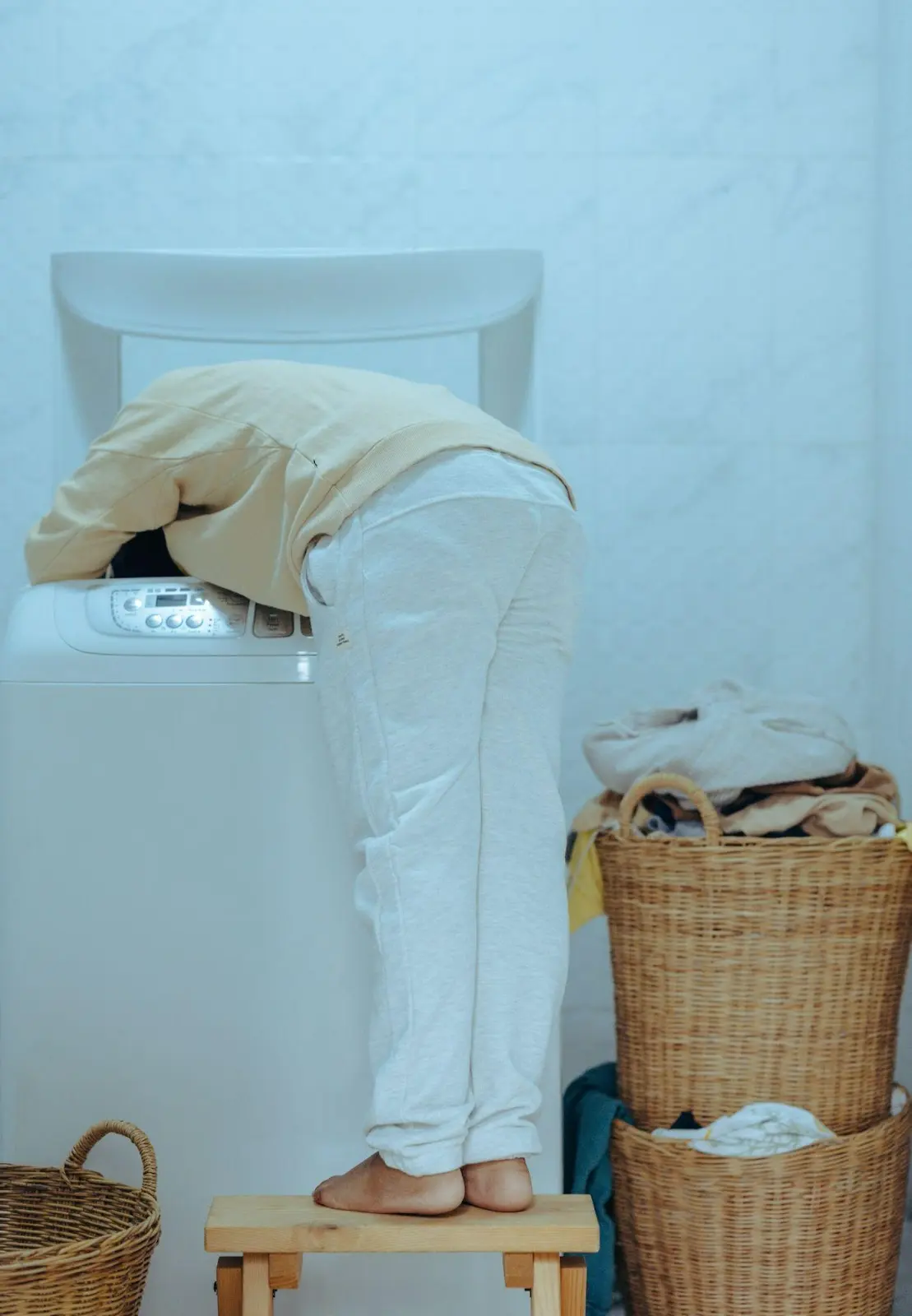 A man with buckets of clothes and washing machine