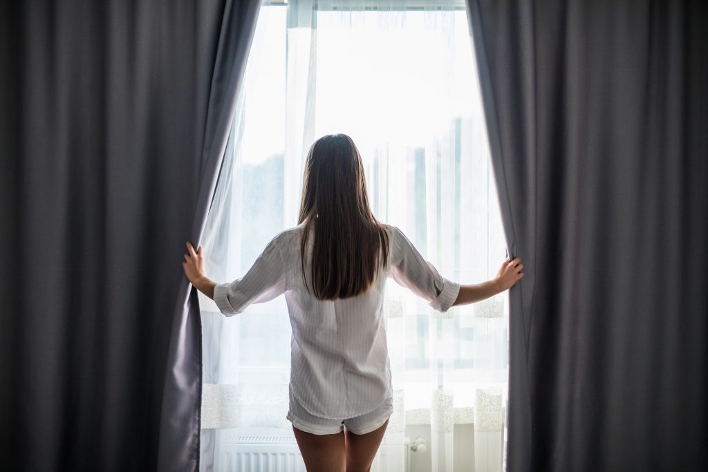 happy-beautiful-girl-opening-curtains