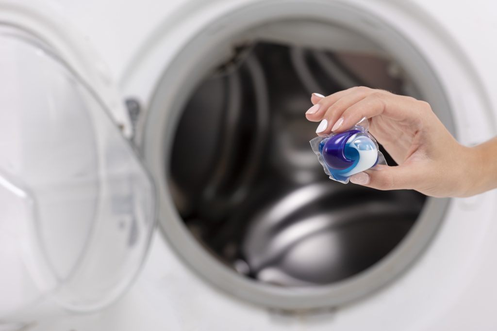Woman-holding-a-washing-machine-cleaner-tablet-in-hands