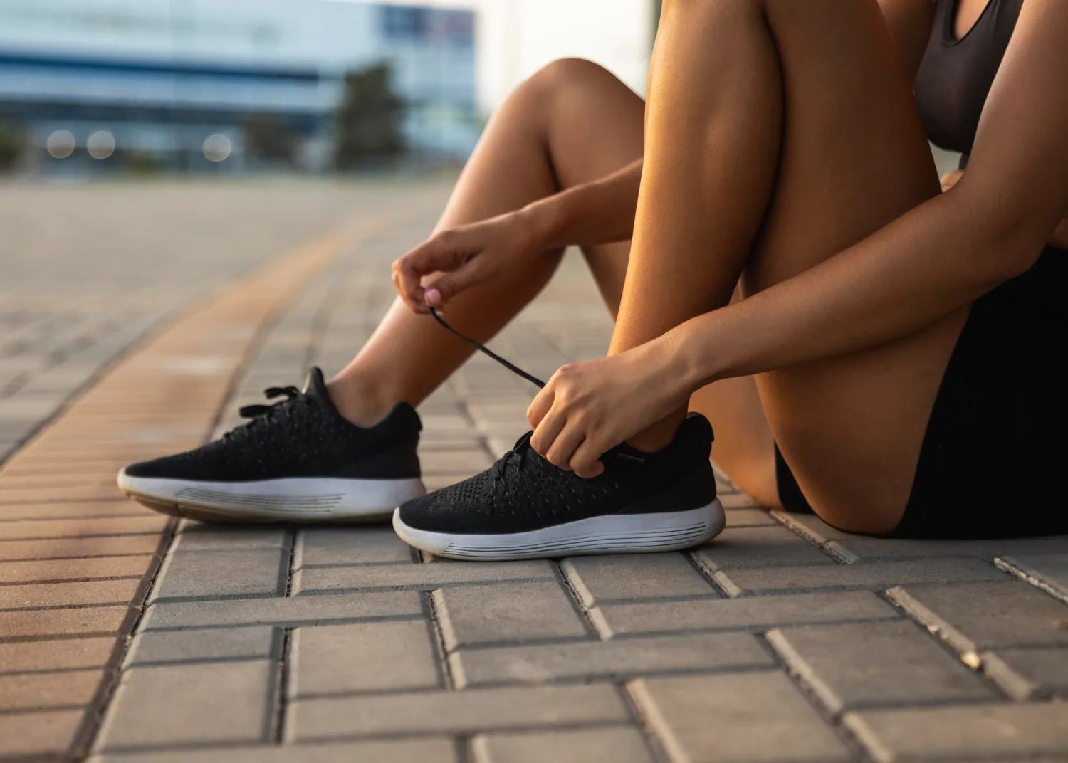 A lady tying her shoe laces.