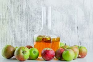 ripe-apples-with-drink-white-grungy-side-view (1)